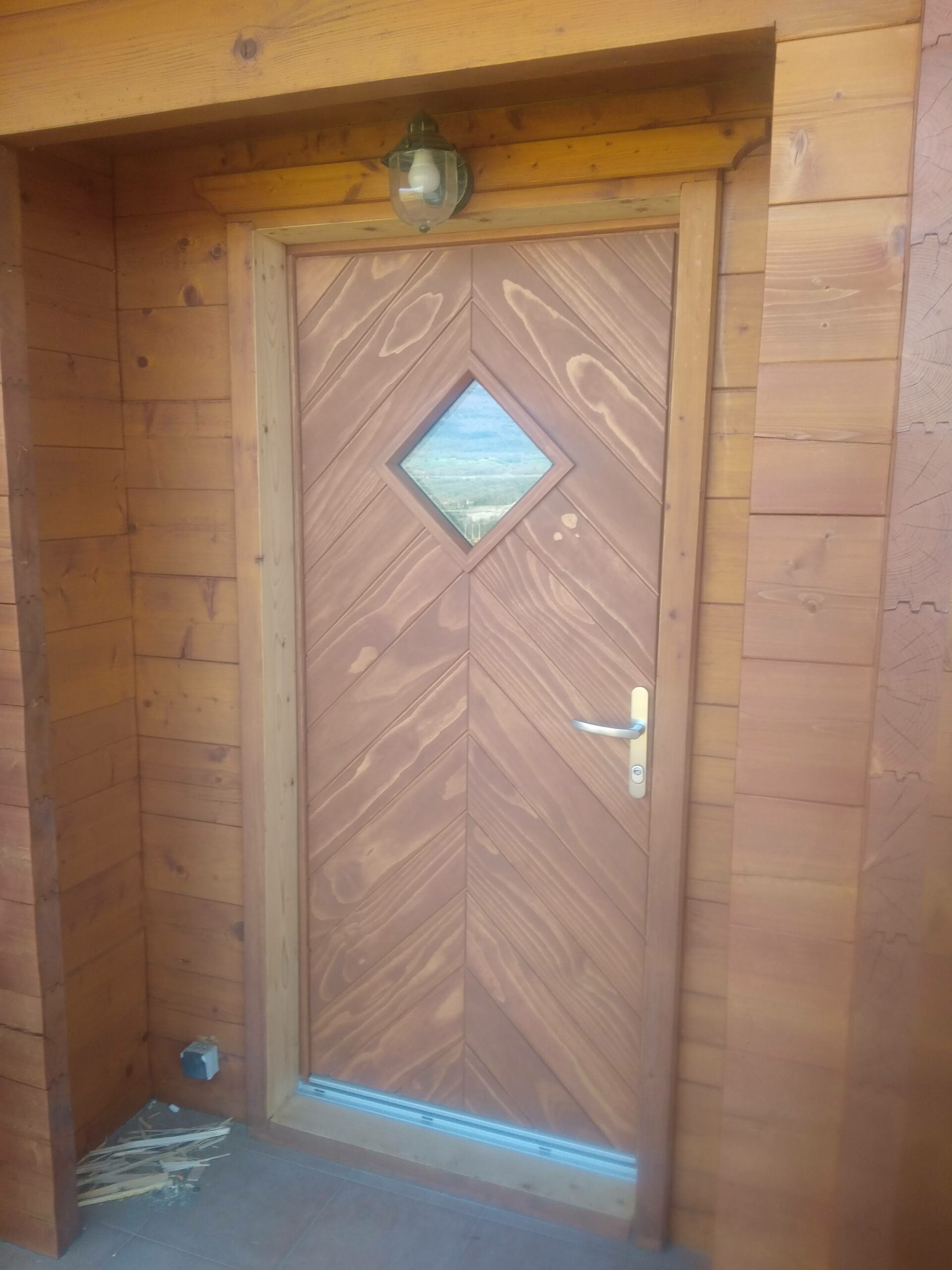 Porte d'entrée en bois harmonisée avec à l'ossature bois
